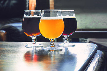 Image showing Glasses of different kinds of beer on wooden background