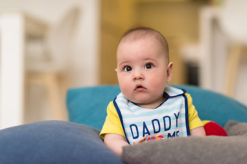 Image showing baby boy sitting between the pillows on sofa