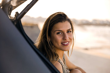 Image showing Girl near the beach sitting on the car