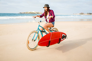 Image showing Surfer girl riding a bicyicle