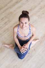 Image showing Fit sporty active girl in fashion sportswear sitting on the floor in yoga studio. Active urban lifestyle