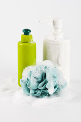 Image showing Bath cosmetic products, green sponge and foam on light backgroun