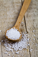 Image showing Wooden spoon with sea salt closeup on wooden rustic table.
