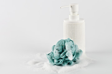 Image showing Liquid soap, green sponge and foam on light background.