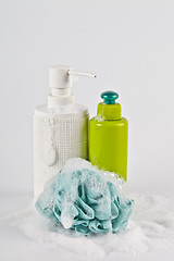 Image showing Bath cosmetic products, green sponge and foam on light backgroun