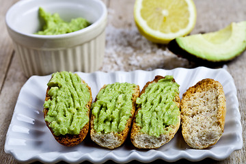 Image showing Fresh crostini with avocado guacamole on white plate closeup on 