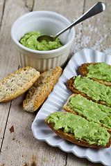 Image showing Croutons with avocado guacamole on white plate closeup on rustic