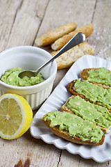 Image showing Toasts with avocado guacamole on white plate closeup on rustic w