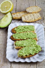 Image showing Fresh crostini with avocado guacamole on white plate closeup on 