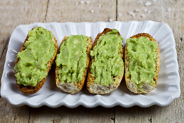 Image showing Fresh crostini with avocado guacamole on white plate closeup on 