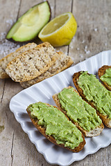 Image showing Fresh crostini with avocado guacamole on white plate closeup on 