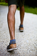 Image showing Low angle ground level view with feet of a man on park or forest