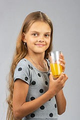 Image showing The girl proudly holds a glass of juice