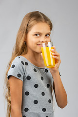 Image showing A ten-year-old girl drinks juice, and with a smile looked at the frame