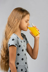 Image showing Ten-year girl drinks juice, profile view