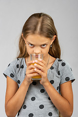 Image showing A ten year old girl drinks juice and enjoys the scent
