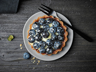 Image showing blueberry tart on dark wooden table