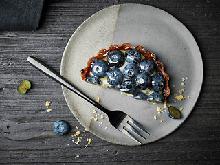 Image showing blueberry tart on dark wooden table