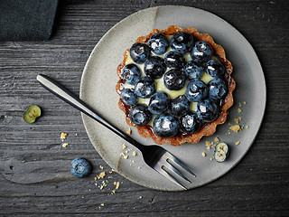 Image showing blueberry tart on dark wooden table