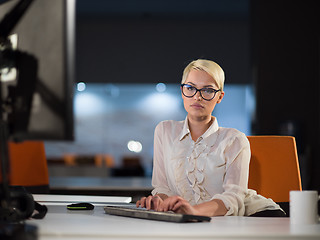 Image showing woman working on computer in dark office