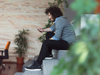 Image showing Young casual businessman holding smartphone