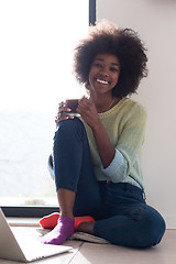 Image showing black woman in the living room on the floor