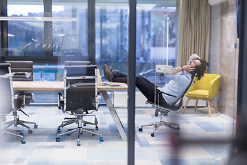 Image showing young businessman relaxing at the desk