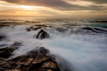 Image showing Mystical light over the ocean  with rocky ocean cascades