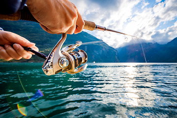 Image showing Woman fishing on Fishing rod spinning in Norway.