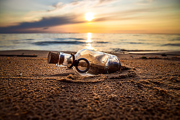 Image showing Message in the bottle against the Sun setting down