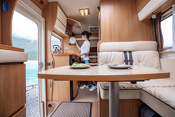 Image showing Woman cooking in camper, motorhome interior