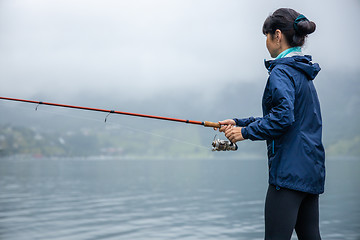 Image showing Woman fishing on Fishing rod spinning in Norway.