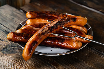 Image showing Grilled sausages on wooden board