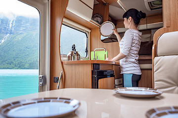 Image showing Woman cooking in camper, motorhome interior