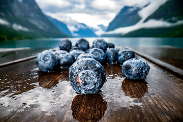 Image showing Blueberry antioxidants on a wooden table on a background of Norw