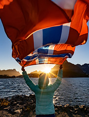 Image showing Woman waving the flag of Norway at sunset