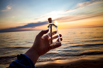 Image showing Message in the bottle against the Sun setting down