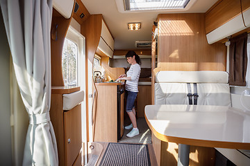 Image showing Woman cooking in camper, motorhome interior