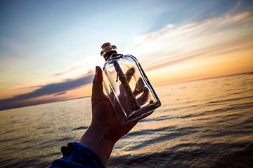 Image showing Message in the bottle against the Sun setting down