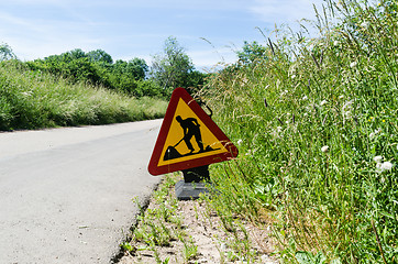 Image showing Roadwork sign by roadside among green grass