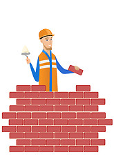 Image showing Young bricklayer working with spatula and brick.