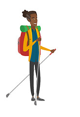 Image showing Young african hiker walking with trekking sticks.