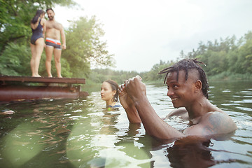 Image showing Enjoying river party with friends. Group of beautiful happy young people at the river together