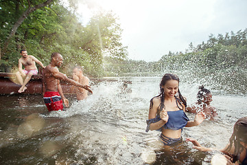 Image showing Enjoying river party with friends. Group of beautiful happy young people at the river together