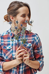 Image showing Young girl with flowers eryngium