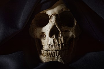 Image showing Closeup photo an old skull covered in black robe