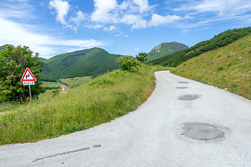 Image showing some street signs on a steep road