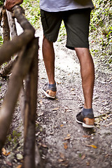 Image showing Man's legs on park or forest footpath with handrail closeup. 