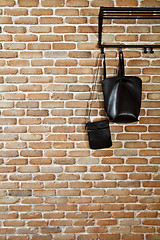 Image showing Modern hallway loft interior and black leather bags on hanger ag