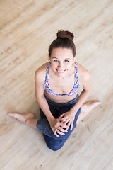 Image showing Fit sporty active girl in fashion sportswear sitting on the floor in yoga studio. Active urban lifestyle